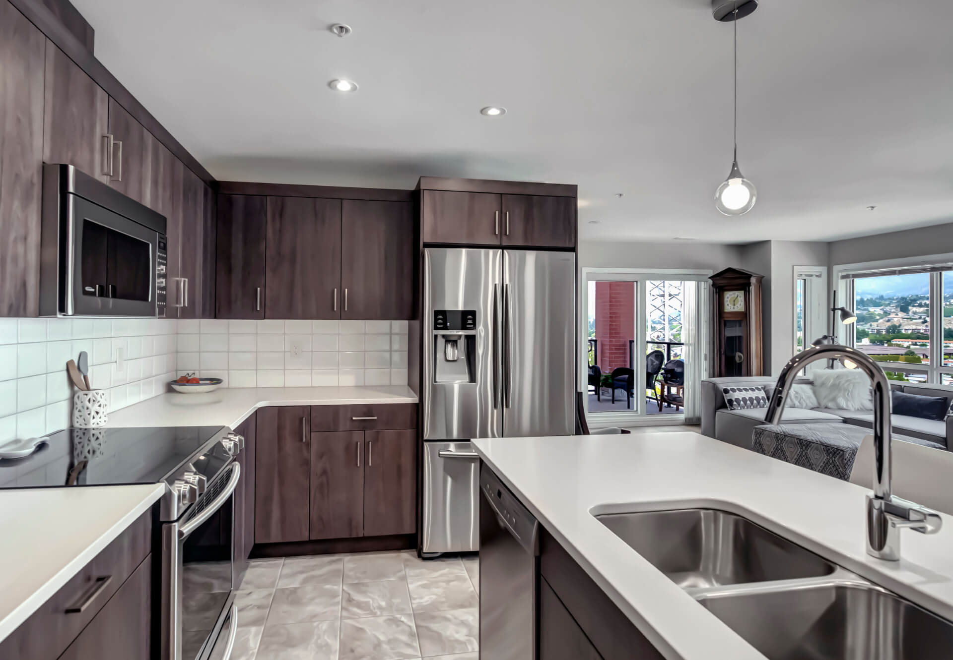 Photo of kitchen with stainless steel appliances, and brown cabinets.